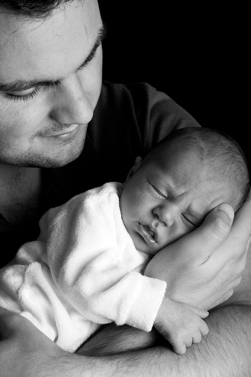 New father holding newborn baby in arms – a bonding and parenting moment