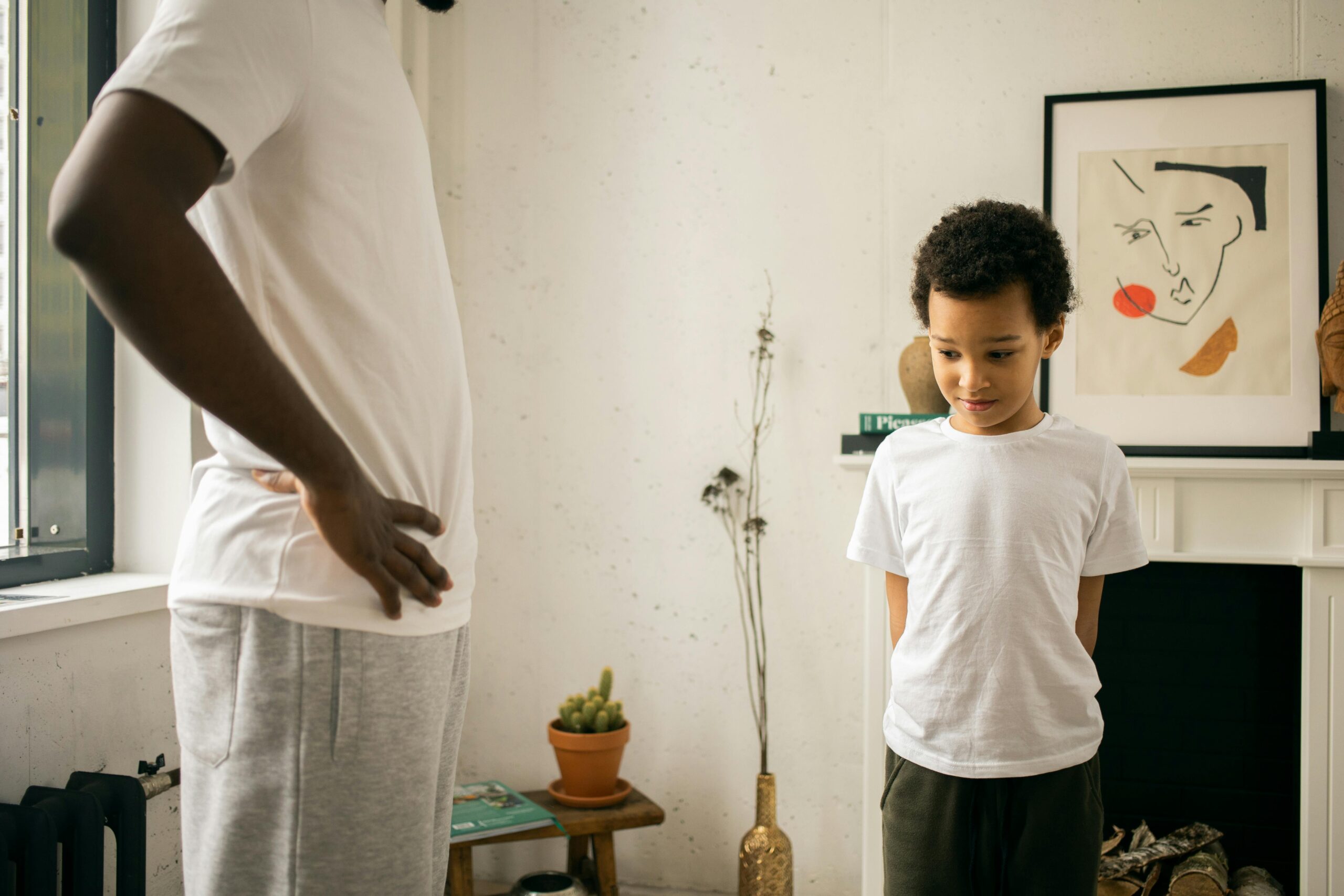 A father and son share a serious moment indoors, representing parenthood and family dynamics.