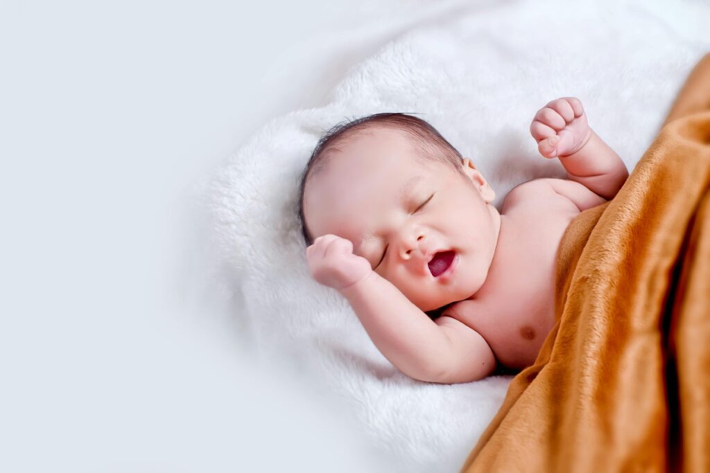 Peaceful newborn wrapped in a soft white blanket — newborn care essentials.