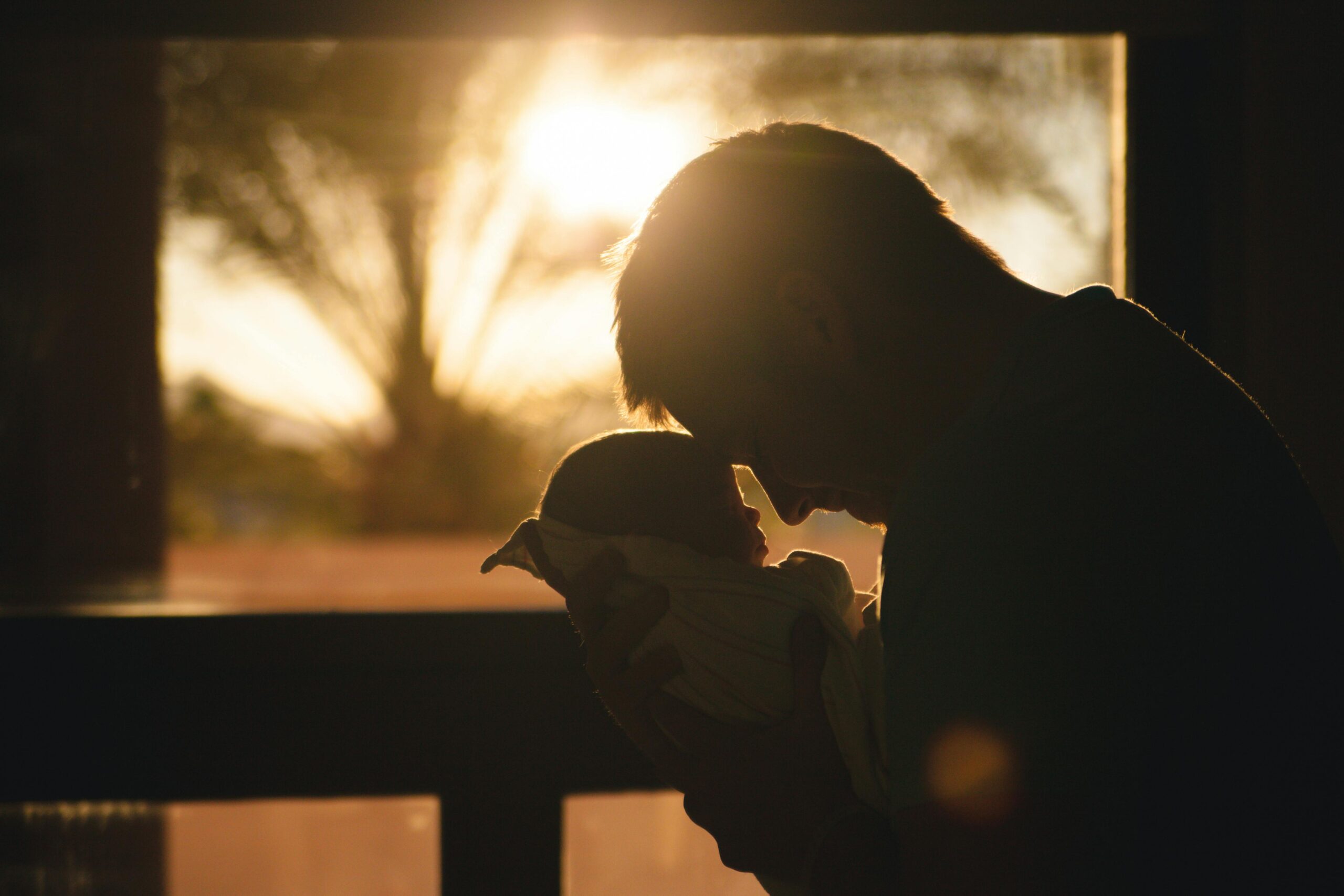 Father holding his baby in his hands, admiring the baby. The real fatherhood