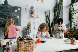 Curious children conducting science experiments in a classroom with flasks and a microscope.